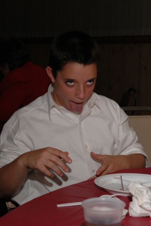 1985 Ford Crown Victoria LTD - A young boy makes a silly face while sitting at a table with a plate and cup.