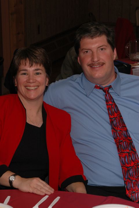 1985 Ford Crown Victoria LTD - A couple smiles for the camera while seated at a table, possibly during an event.