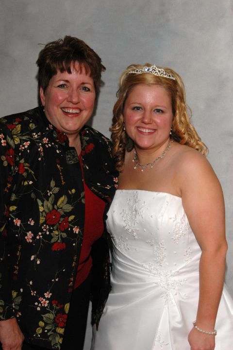 1985 Ford Crown Victoria LTD - A bride and another woman pose for a picture, both smiling at the camera.