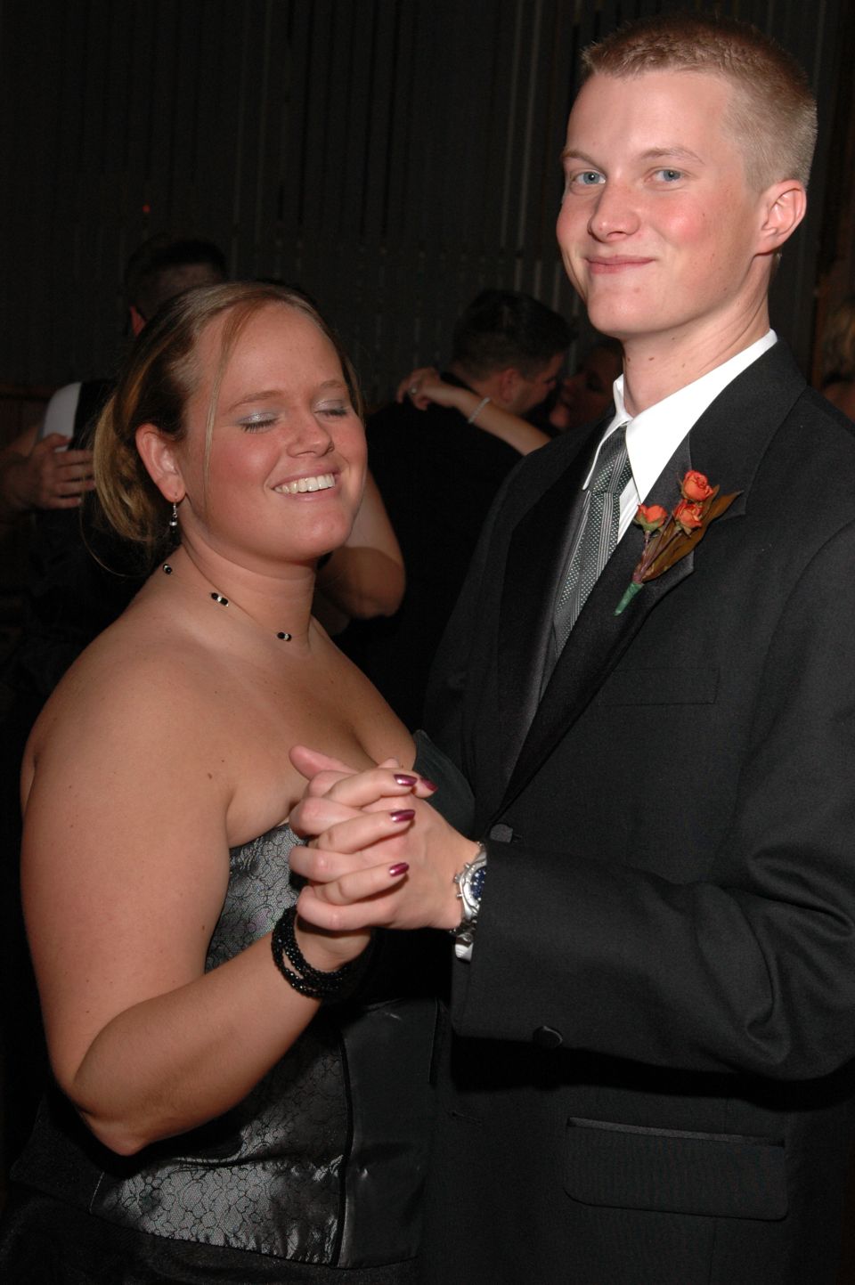 Couple dancing at an event, woman in a strapless dress, man in a tuxedo