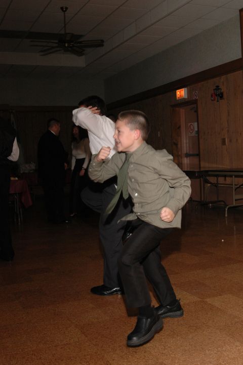 1985 Ford Crown Victoria LTD - Boys are dancing in a room with tables and chairs in the background.