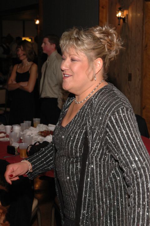 1985 Ford Crown Victoria LTD - A woman smiles while standing at a table with drinks and party decorations.