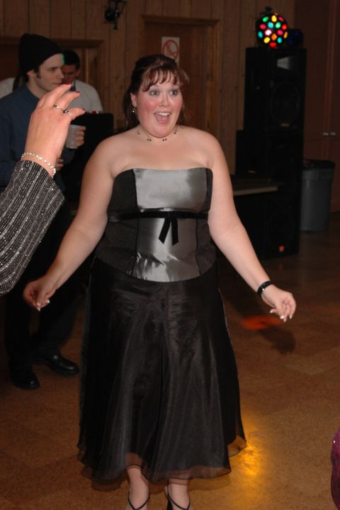 1985 Ford Crown Victoria LTD - A woman dances at a formal event, with other people in the background and a disco ball overhead.