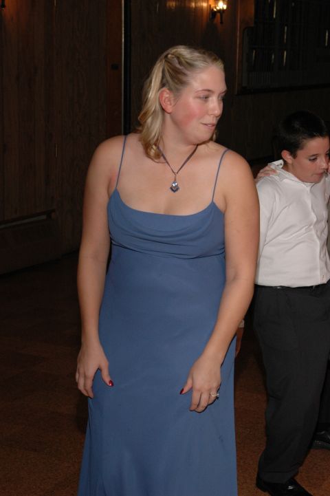 1985 Ford Crown Victoria LTD - A woman in a blue dress stands with another person in the background at an event.