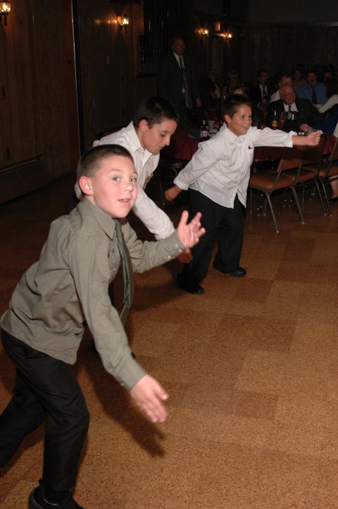 1985 Ford Crown Victoria LTD - Boys in formal attire are captured mid-dance at an indoor event.