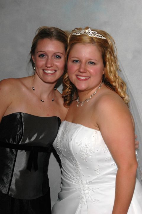 1985 Ford Crown Victoria LTD - A bride and her bridesmaid pose for a photo, both smiling warmly at the camera.