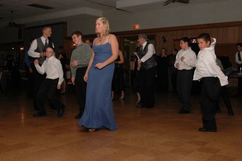 1985 Ford Crown Victoria LTD - A group of people are dancing at an indoor event, possibly a wedding reception or formal gathering.