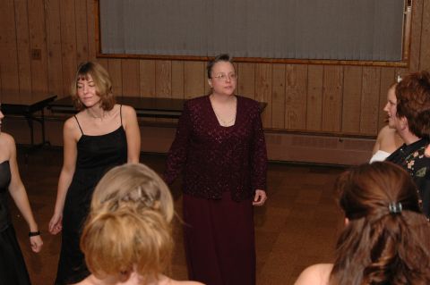 1985 Ford Crown Victoria LTD - Women in dresses gather indoors, possibly for a formal event.