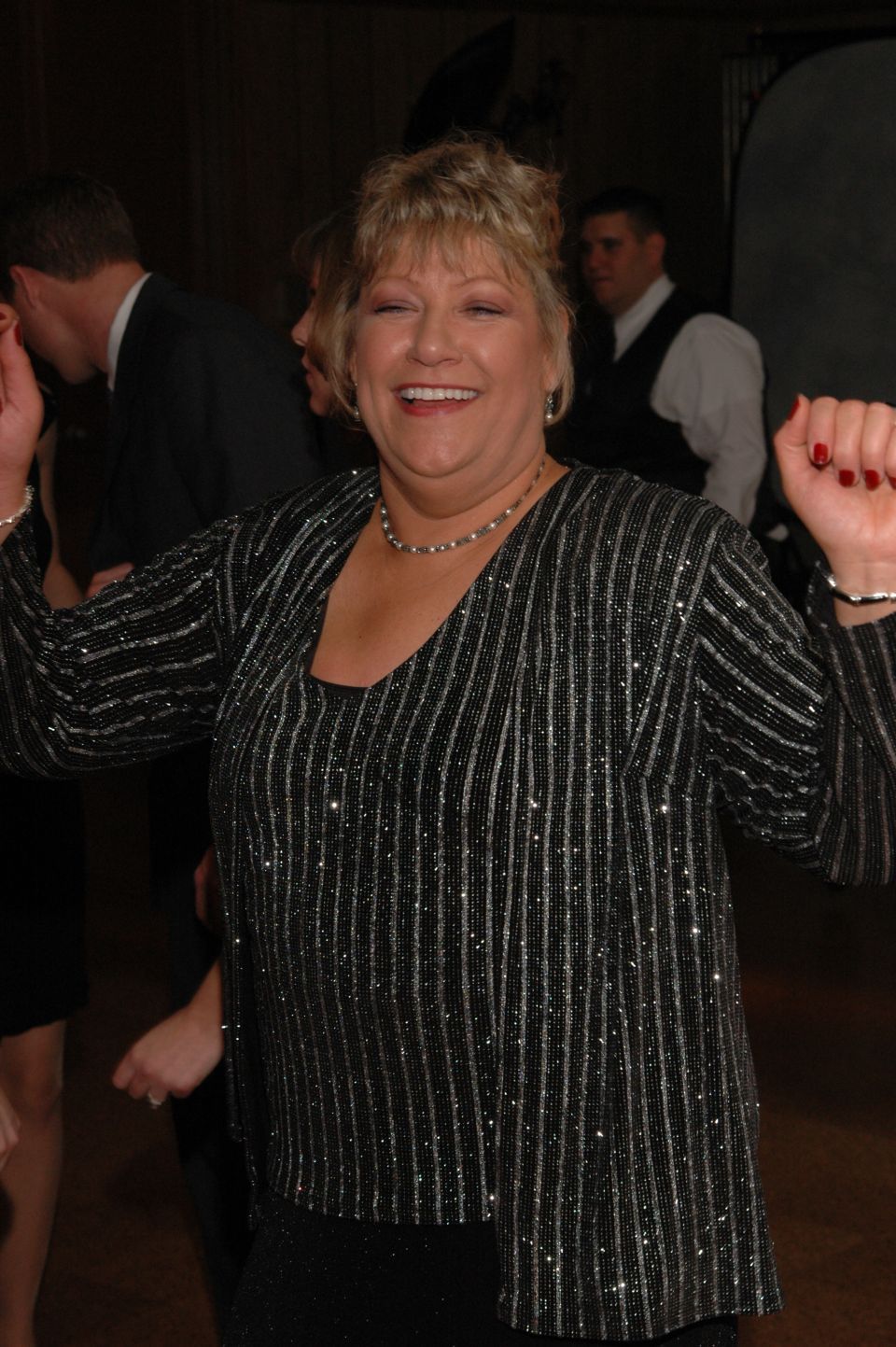 Woman in sparkly top dancing at a wedding reception
