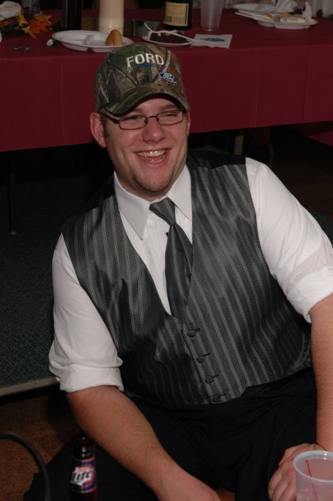 Man in a camo Ford hat and vest smiles