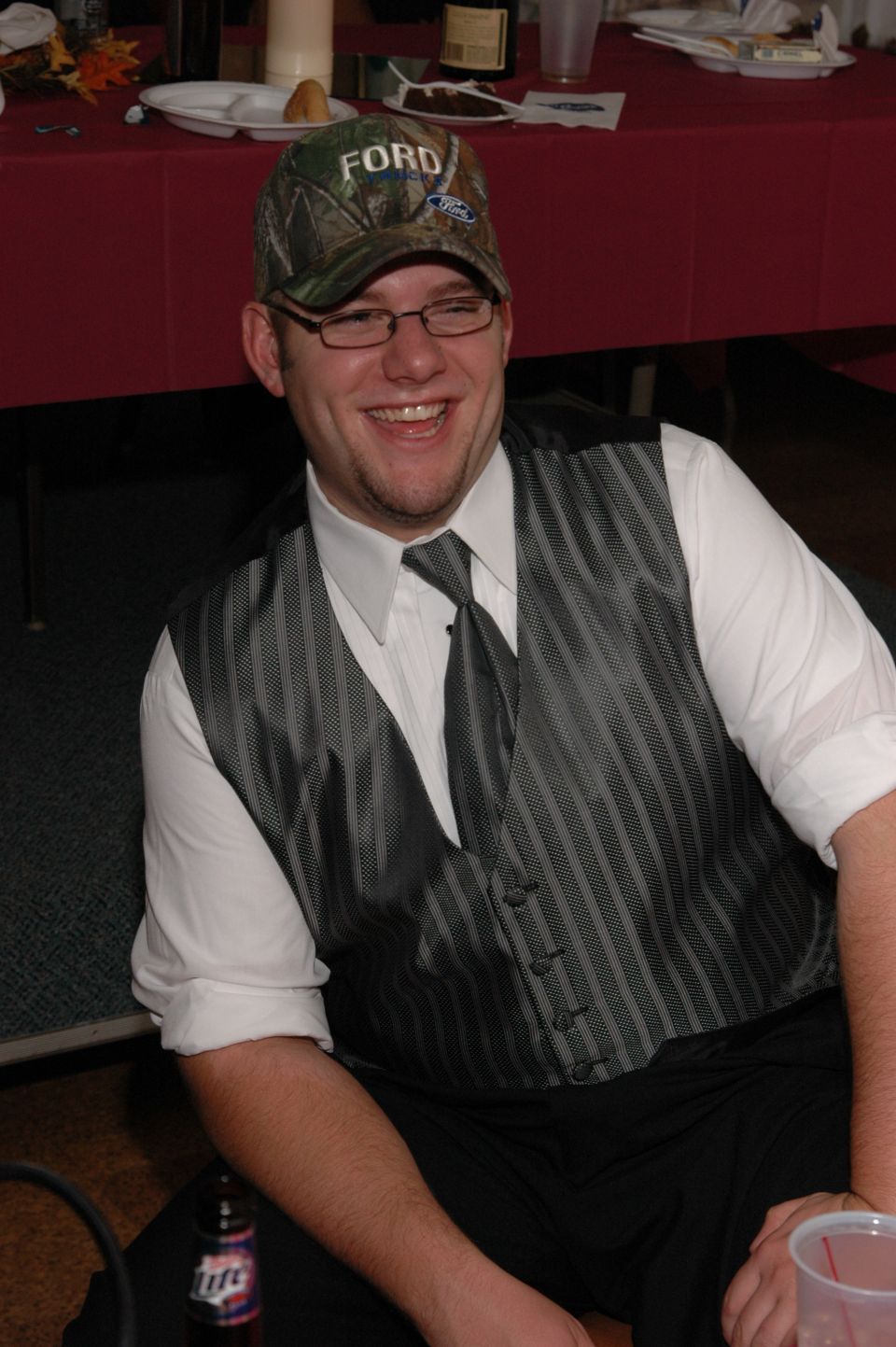 Man in a camo Ford hat and vest smiles