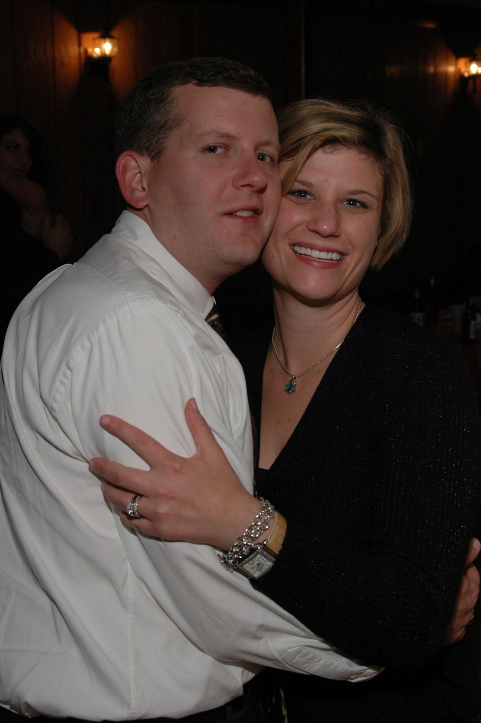Couple embracing, the man wears a white shirt and the woman wears a black top