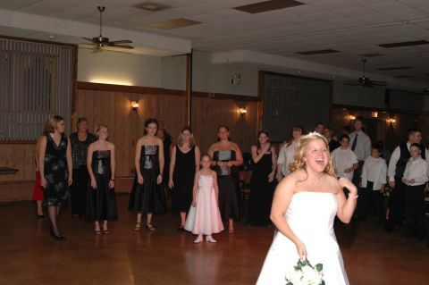 Wedding party gathered indoors, bride in foreground