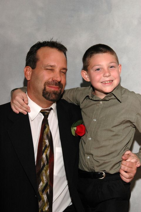 Man with goatee and closed eyes, and a smiling boy with his arm around him