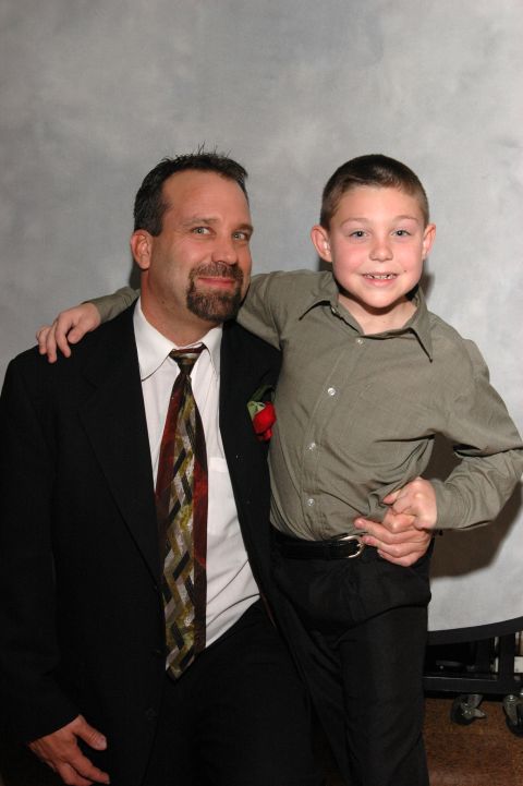 Man in a suit and tie with a boy in a collared shirt, posing for a photo