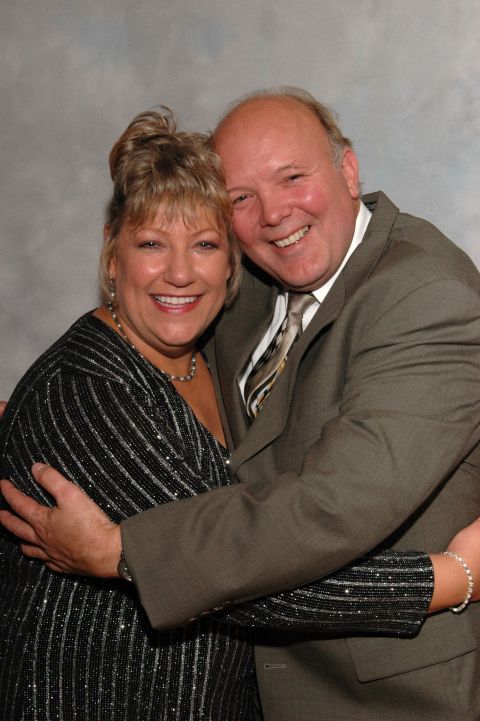 Man in suit hugs woman in sparkly dress