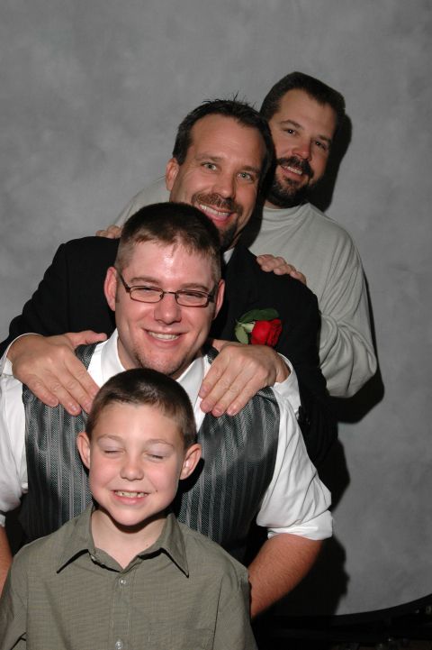 Four men and a boy posing for a wedding photo