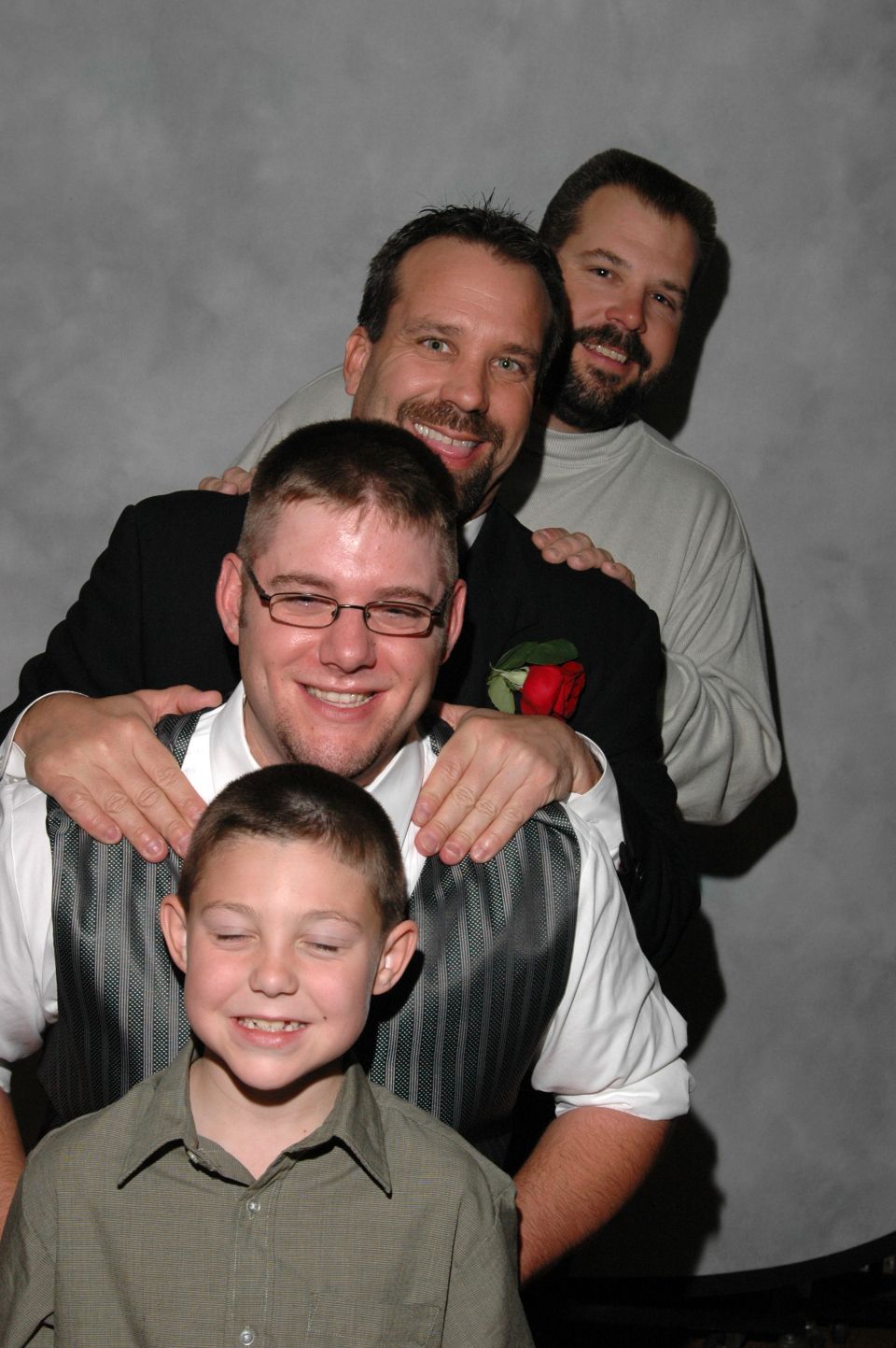 Four men and a boy posing for a wedding photo
