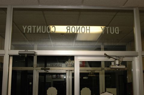 Reflection of 'DUTY HONOR COUNTRY' text on glass doors