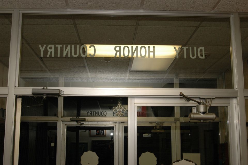 Reflection of 'DUTY HONOR COUNTRY' text on glass doors
