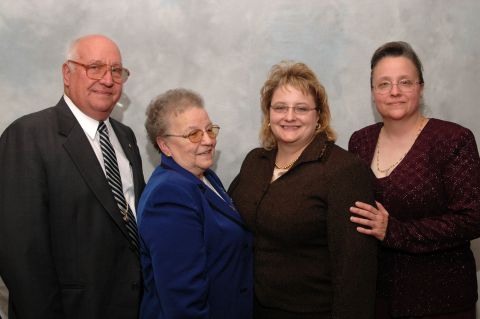 four people, two men and two women, posing for a photo