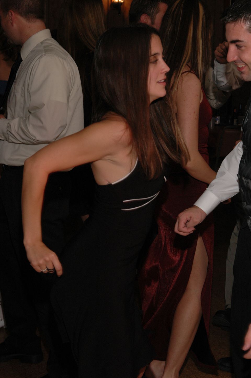 Woman in black dress dancing next to people in formal wear