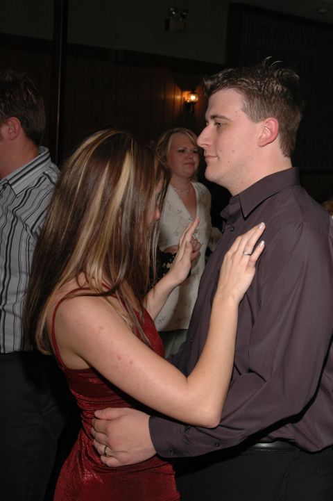 Couple dancing at an event, woman in red dress, man in dark shirt