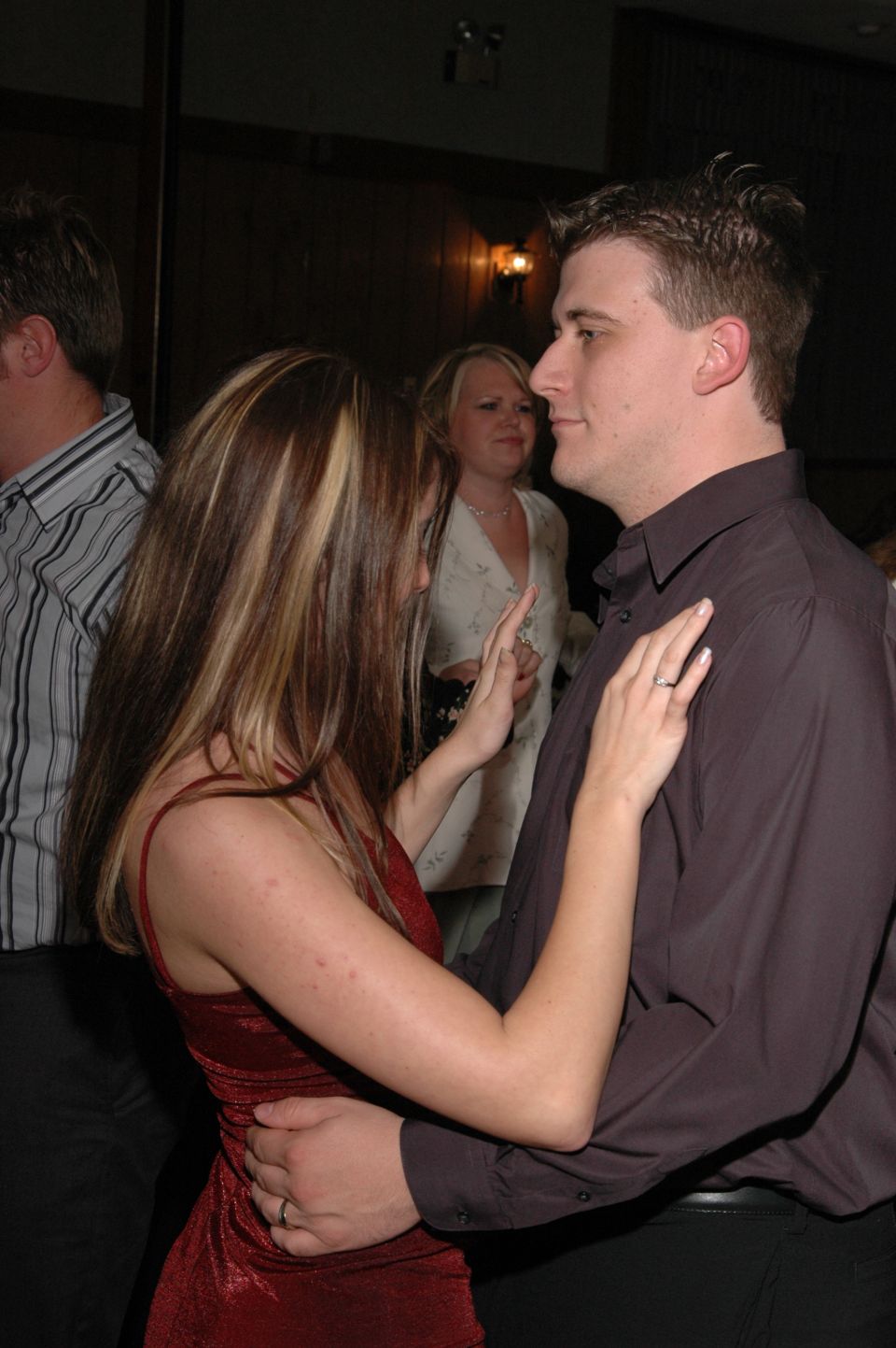 Couple dancing at an event, woman in red dress, man in dark shirt