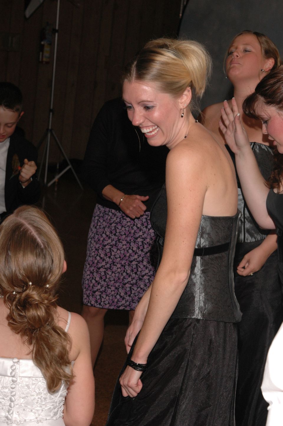 Women in formal dresses laughing at a wedding reception