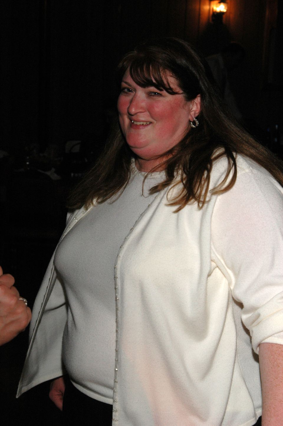 Woman in a white cardigan and top, smiling