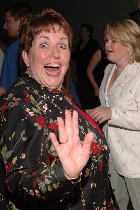 Woman with surprised expression waving hello