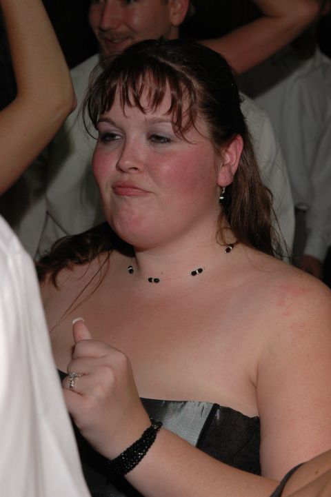 Woman with dark hair and a strapless dress at an indoor event