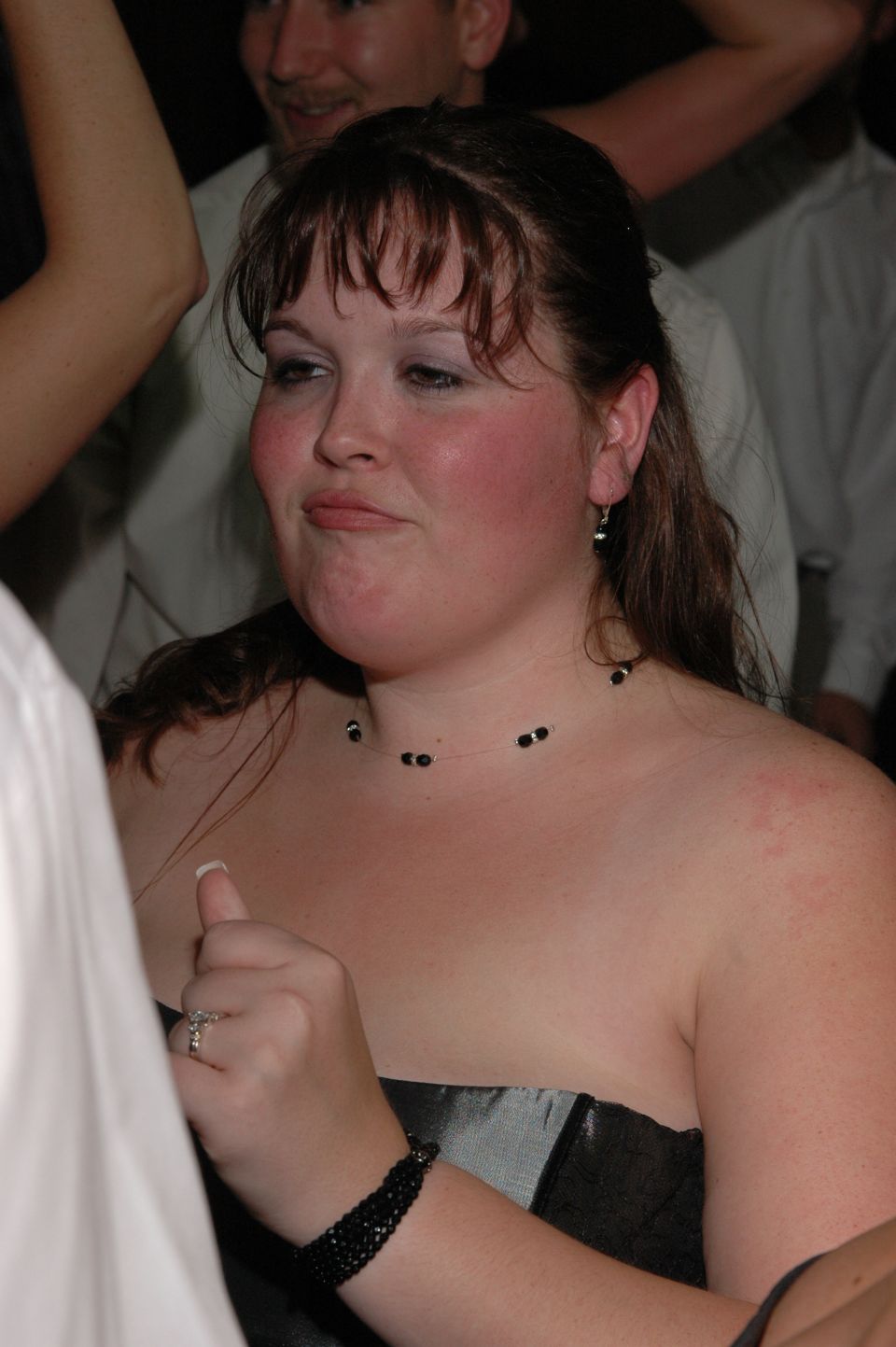 Woman with dark hair and a strapless dress at an indoor event