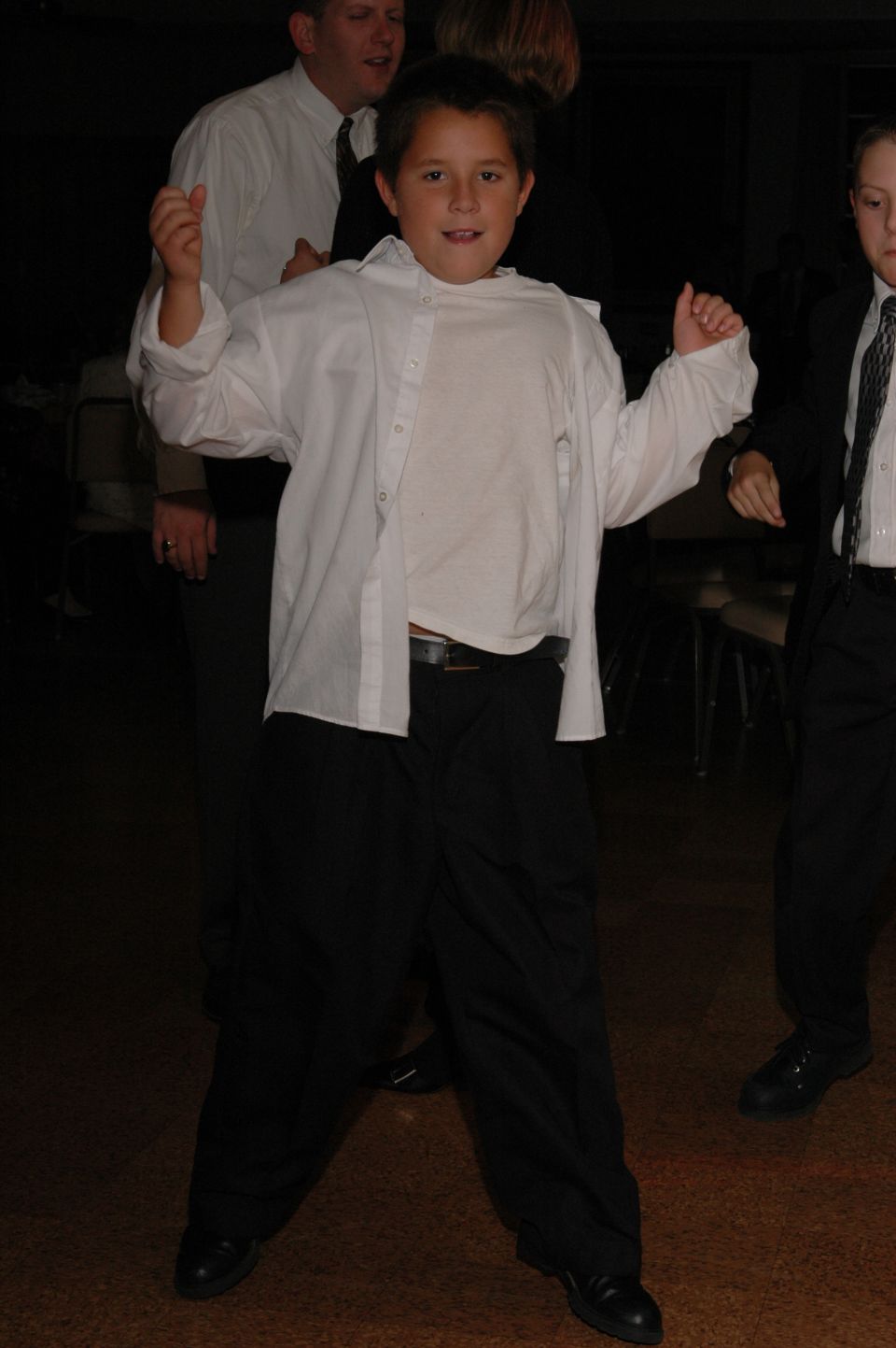 Boy in an oversized white shirt and black pants dancing