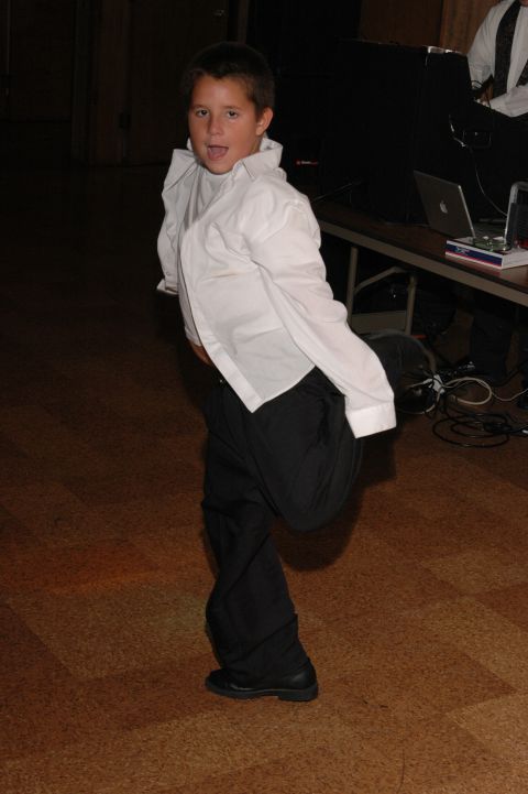 Boy in white shirt and black pants dancing
