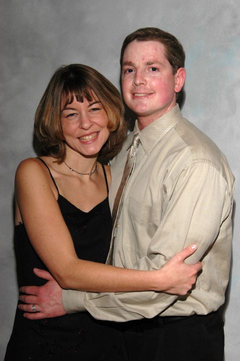Couple posing for a photo, man has arms around woman