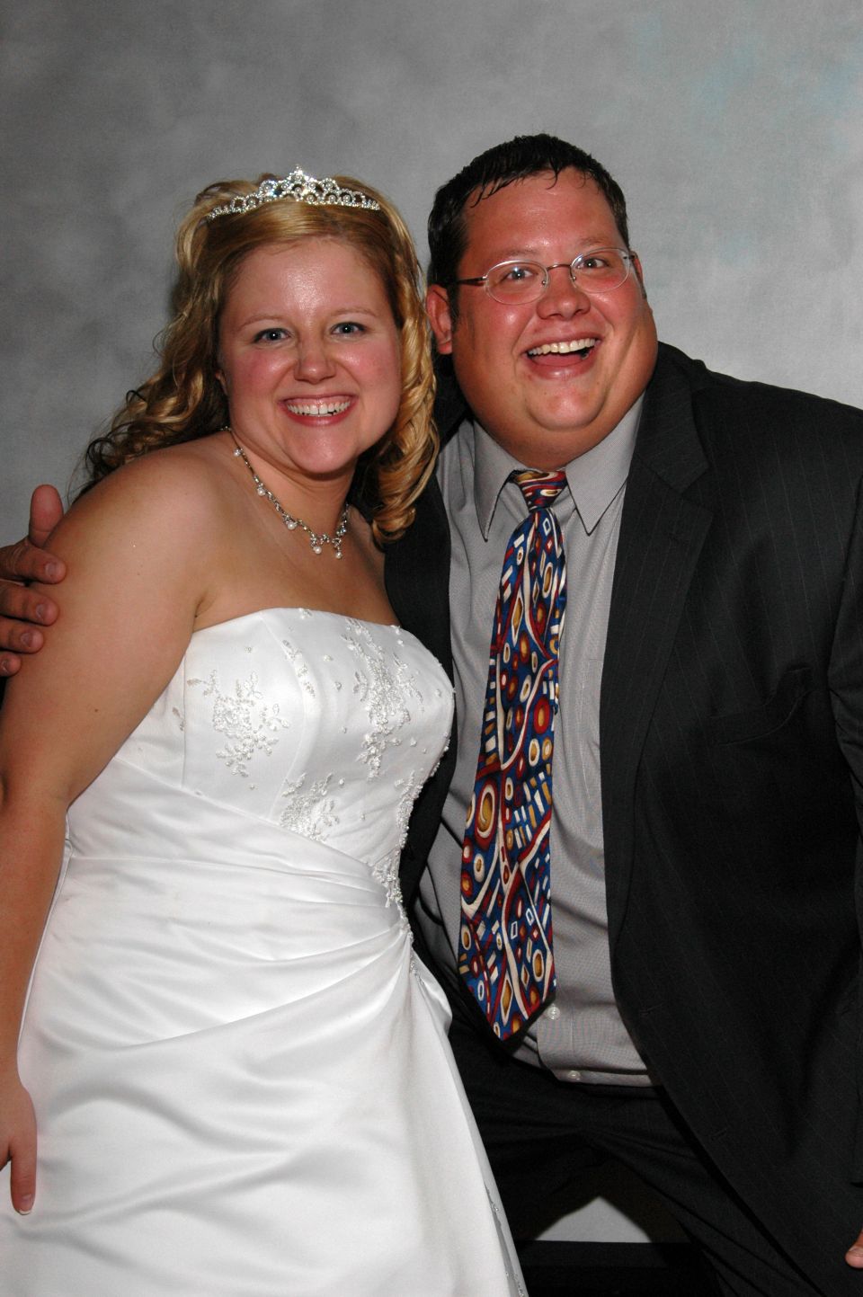 Bride in white wedding dress and groom in suit and tie smile for the camera