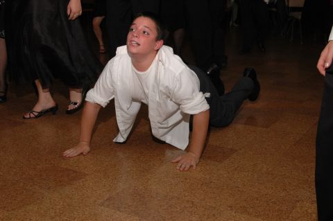 Person crawling on a wood-paneled floor at an event