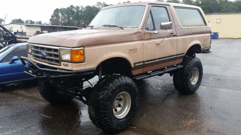 1988 Ford Bronco - This lifted Ford Bronco has a two-tone paint job and aggressive off-road tires.