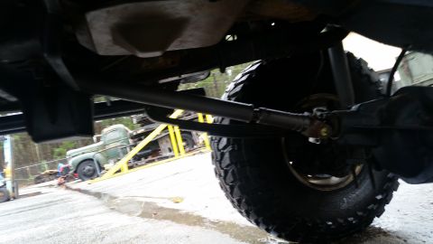1988 Ford Bronco - The photo shows the undercarriage of a vehicle, with another truck visible on a trailer in the background.