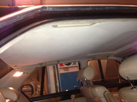 1988 BMW 7 Series - Interior view of a car, focusing on the headliner and seats, with a glimpse of the outside.