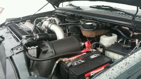 2003 Ford Excursion - Close-up of a Ford Power Stroke diesel engine, including the battery and radiator.