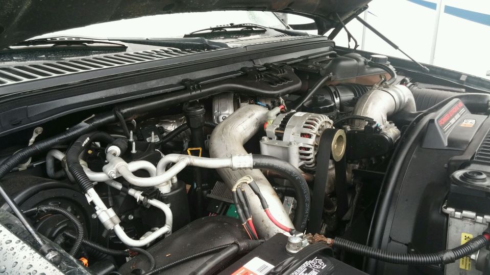 Engine bay with large turbocharger intake pipe and alternator visible