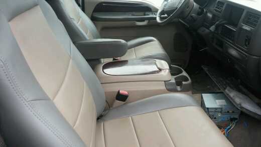 2003 Ford Excursion interior showing front seats, center console, and dashboard