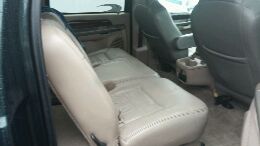 2003 Ford Excursion - The interior of a large SUV, showing the rear seating area and center console.