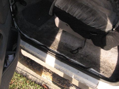 1994 Ford Bronco - The interior door sill shows significant rust and debris, indicating potential wear and tear.