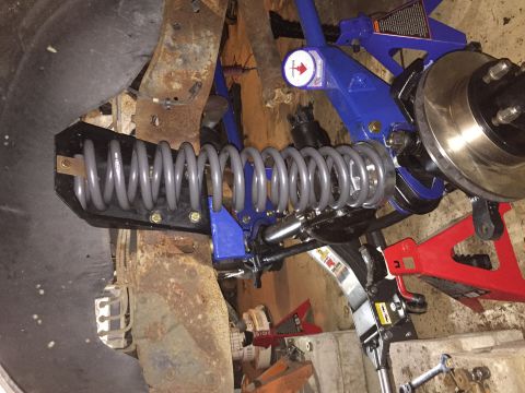 1994 Ford Bronco - Close-up view of a vehicle's suspension system, showing a coil spring and brake components.