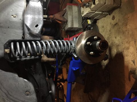 1994 Ford Bronco - Close-up of a vehicle's front suspension and brake components during maintenance.