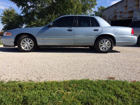 2003 Ford Crown Victoria - Side view of a light blue 2003 Ford Crown Victoria sedan parked outdoors.
