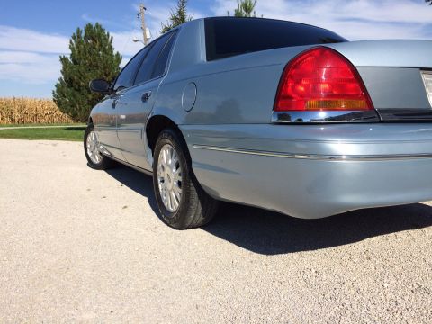 2003 Ford Crown Victoria - Rear view of a light blue 2003 Ford Crown Victoria parked outdoors on a sunny day.